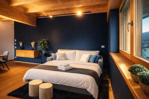 a bedroom with a large bed with a blue wall at GLETSCHERBLICKSTUBE - Terrace & Mountain View in Fügen +21 photos