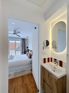 a bedroom with a bed and a sink and a mirror at Maison Plage - boutique hôtel in Saint-Brevin-les-Pins