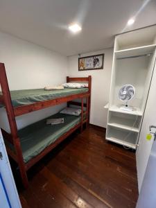 a room with two bunk beds and a refrigerator at Sunset Hostel in Brasília