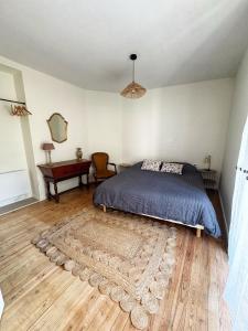 a bedroom with a bed and a rug on a wooden floor at Escapade Lotoise in Cahors