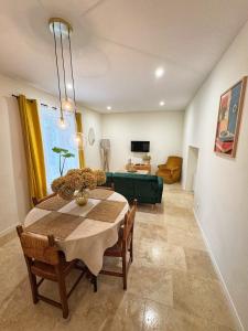 a dining room with a table and a green couch at Escapade Lotoise in Cahors