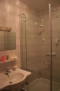 a bathroom with a shower and a sink and a tub at TIPTOP Hotel Garni Pfauen in Endingen