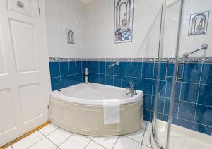 a bathroom with a tub and a glass shower at The Tides Ballybunion in Ballybunion +61 photos