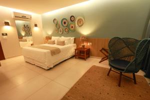 a bedroom with a bed and a chair and a mirror at Hotel Manati in Barra Grande +110 photos