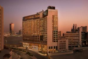 a tall building with a sign on top of it at JW Marriott Hotel Kuwait in Kuwait