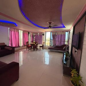 a living room with purple lights on the ceiling at Rooftopwaves penthouse in Daman
