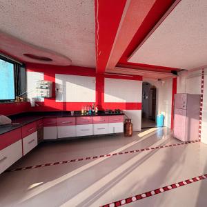 a large kitchen with red and white walls and ceilings at Rooftopwaves penthouse in Daman +9 photos