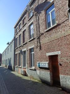 a brick building with a door on the side of a street at Mons 21C in Mons