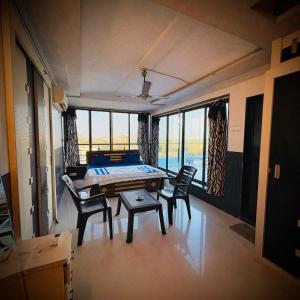 a room with a table and chairs and windows at Rooftopwaves penthouse in Daman
