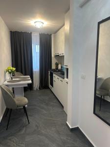 a room with a kitchen and a table and a mirror at Nova Residence Craiova in Craiova +9 photos
