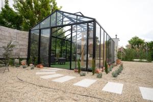 a glass greenhouse in the middle of a garden at Casa Oliva Tokaj in Tokaj