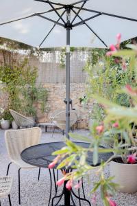 a table and chairs with an umbrella on a patio at Studio lumineux avec jardin privé et parking in La Turbie