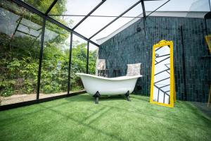 a bath tub sitting in a room with grass at Casa Oliva Tokaj in Tokaj