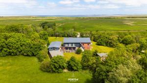 an aerial view of a house on a green field at Ferienwohnung Lille Hus 2 St Peter-Ording in Böhl
