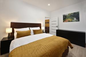 a bedroom with a large bed with a yellow blanket at Apartmány Virbo in Vrbov +65 photos