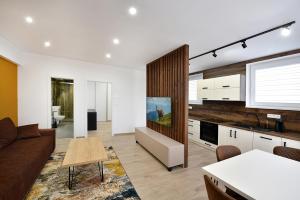 a kitchen and living room with a couch and a table at Apartmány Virbo in Vrbov