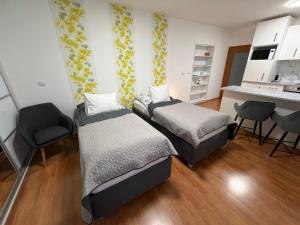a bedroom with two beds and a desk and chairs at Apartment Komin in Komín