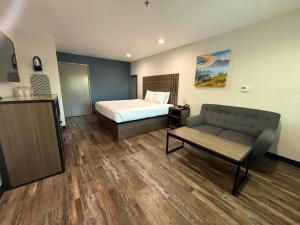 a hotel room with a bed and a couch at Baymont by Wyndham Manteca in Manteca +18 photos