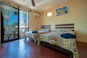 two beds in a bedroom with a balcony at Hotel Rivera Del Mar in Puerto Escondido