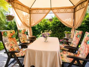 a table with chairs and a vase of flowers on it at Gelbe Koffer - Design-Maisonette in Schiffweiler - private Terrasse & Grill - nahe Wald & See - Self-Check-in - 2 Parkplätze in Schiffweiler