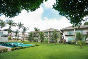 an exterior view of a resort with a pool and palm trees at Hotel Manati in Barra Grande