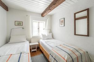 a bedroom with two beds and a mirror at Lütt Kate Hemmelmark in Louisenberg