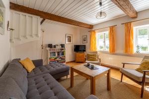 a living room with a couch and a table at Lütt Kate Hemmelmark in Louisenberg