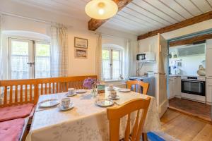 a dining room with a table and a kitchen at Lütt Kate Hemmelmark in Louisenberg
