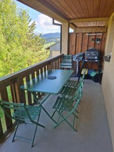 a table and chairs on a deck with a grill at Entre lac et montagne in Les Angles