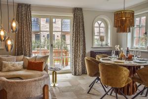 a living room with a table and chairs at Die Perle von Wenningstedt in Braderup