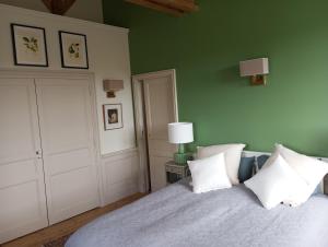 a bedroom with green walls and a bed with white pillows at Château des Boulais Suite in Saint-Martin-le-Bouillant