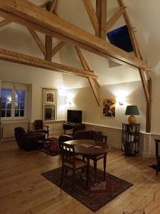 a large living room with a table and chairs at Château des Boulais Suite in Saint-Martin-le-Bouillant