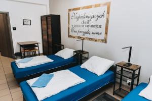 two beds in a room with a sign on the wall at Noclegi Na Końcu Świata Bielpon in Przemyśl