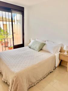 a white bed in a room with a window at Casa Placeta Serna in Vélez-Rubio