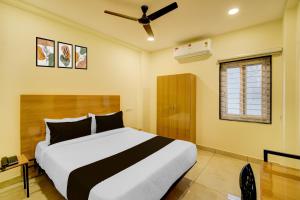 a bedroom with a bed and a ceiling fan at Super Hotel O Nivara in Hyderabad