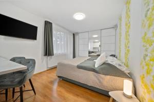 a bedroom with a bed and a desk and a television at Apartment Komin in Komín