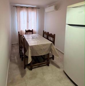 a dining room with a table and a refrigerator at ST-Home in Loutsa +2 photos
