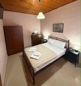 a bedroom with a bed with two towels on it at ST-Home in Loutsa