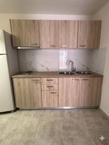 a kitchen with wooden cabinets and a sink at ST-Home in Loutsa