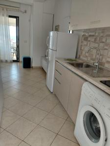 a kitchen with a washing machine and a refrigerator at Monda Apartments Dhermi in Dhërmi