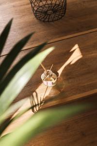 a shadow of a plant and a bowl on a wooden floor at ATRIO Apartments 3 in Trenčín +18 photos