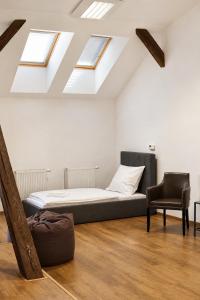 a bed and a chair in a room with skylights at ATRIO Apartments 3 in Trenčín