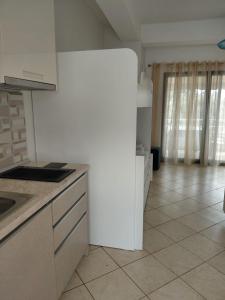 a kitchen with a white refrigerator in a room at Monda Apartments Dhermi in Dhërmi +9 photos