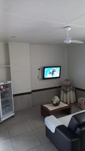 a living room with a couch and a tv on the wall at HL Hotel in Pelotas