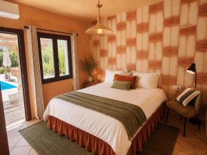 a bedroom with a large bed and a window at Wellness Farm Villa - Monte Valeo in Coín