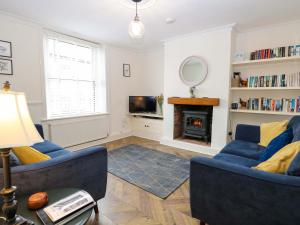 a living room with two blue chairs and a fireplace at Springfield in Fakenham
