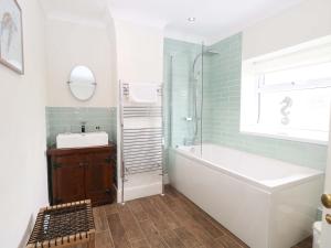 a bathroom with a tub and a sink and a mirror at Springfield in Fakenham +32 photos