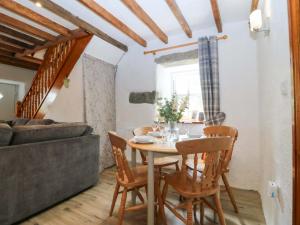 a dining room with a table and chairs and a couch at Old Chapel House in Llanfairfechan