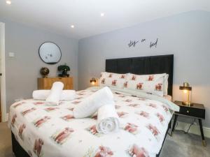 a bedroom with a large bed and a clock on the wall at Old Chapel House in Llanfairfechan