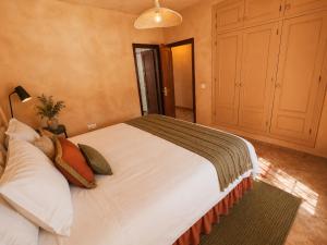 a bedroom with a large white bed with pillows at Wellness Farm Villa - Monte Valeo in Coín